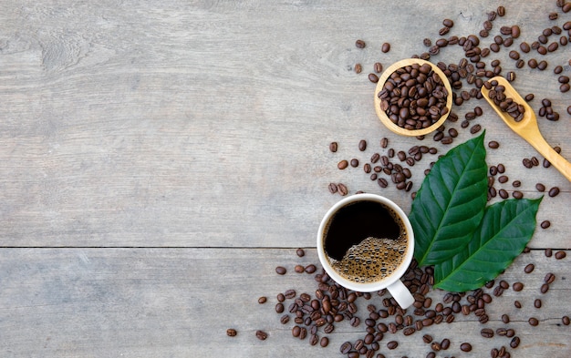 Taza de café y frijoles en la mesa de madera