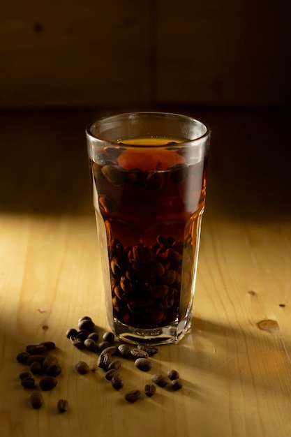 Foto taza de café y frijoles en mesa de madera