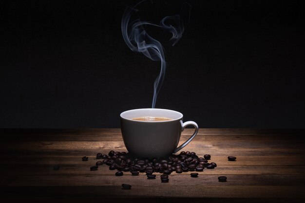 Una taza de café y frijoles en la mesa de madera