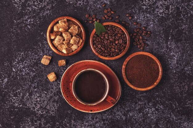 Taza de café, frijoles, polvo molido y azúcar.