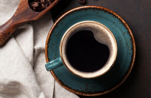 Taza de café y frijoles sobre un fondo blanco