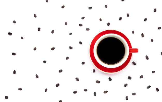 Una taza de café con frijoles sobre fondo blanco.