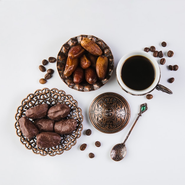 Taza de café con frutas de fechas en la mesa