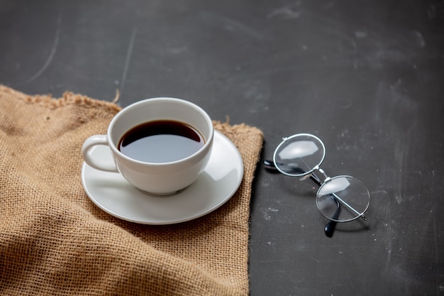 Taza de café y gafas de lectura