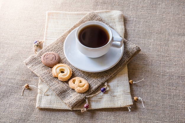 Taza de café y galletas en bolsa de saco de cilicio