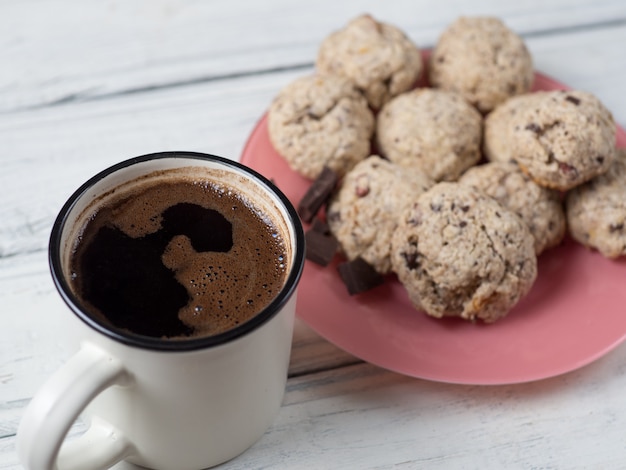 Taza de café y galletas caseras con frutos secos, nueces y cereales.