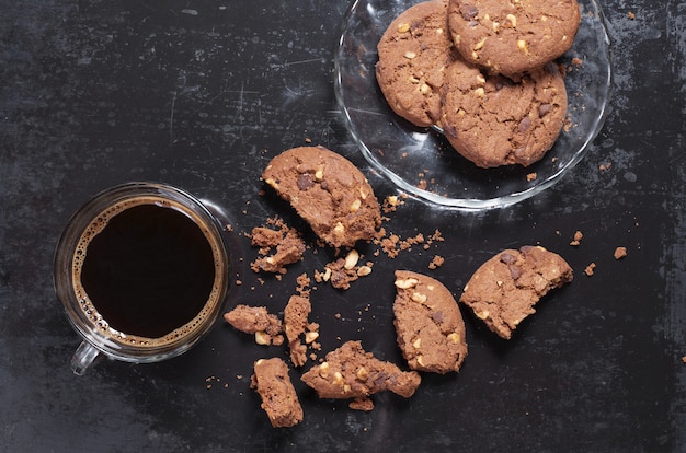 Taza de café y galletas con chispas de chocolate con nueces enteras y rotas