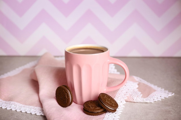 Taza de café y galletas de chocolate con crema en la mesa