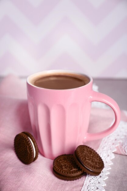 Taza de café y galletas de chocolate con crema en la mesa