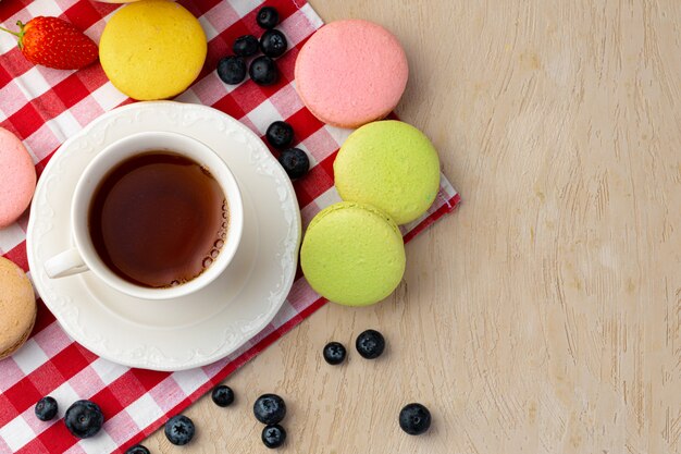 Taza de café con galletas de colores de cerca