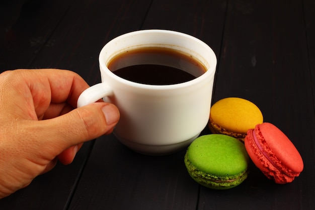 Taza de café y galletas de colores Macaron en el plato