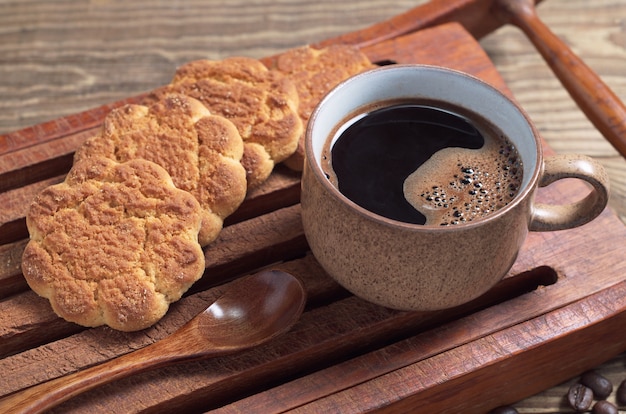 Foto taza de café y galletas de mantequilla en una bandeja de madera