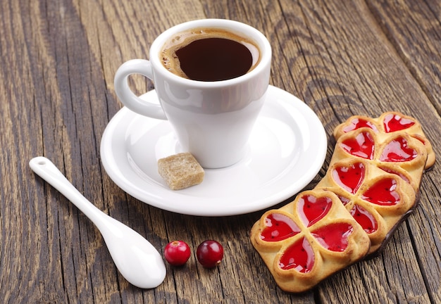 Taza de café y galletas con mermelada y arándano