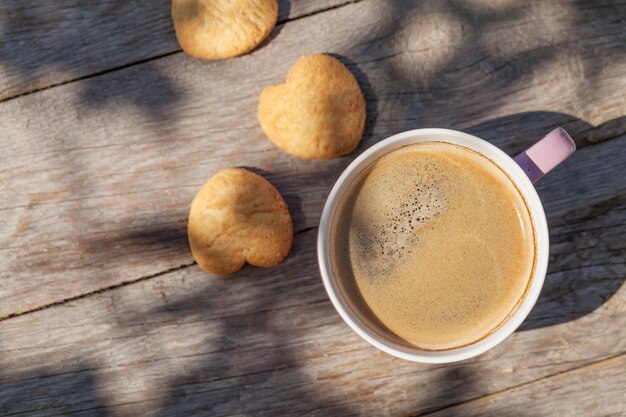 Taza de café y galletas en la mesa de jardín