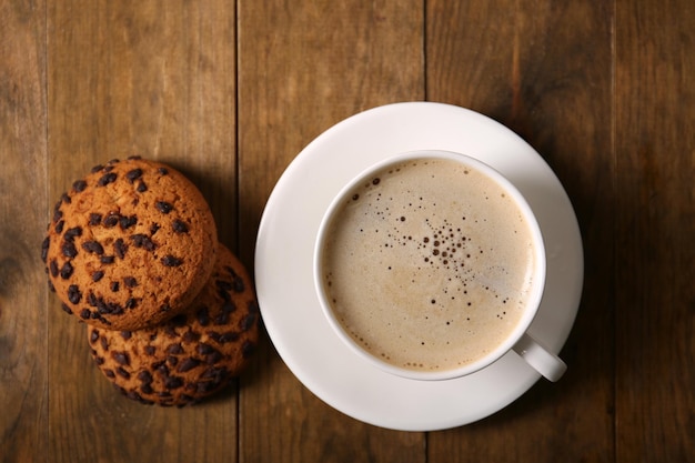 Taza de café con galletas en la vista superior de la mesa de madera