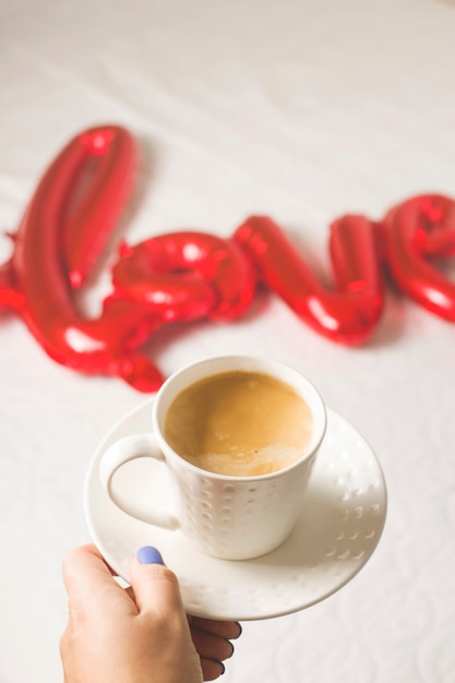 Taza de café y globos en forma de amor.