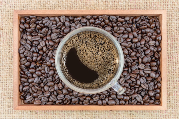 Taza de café y granos de café en caja