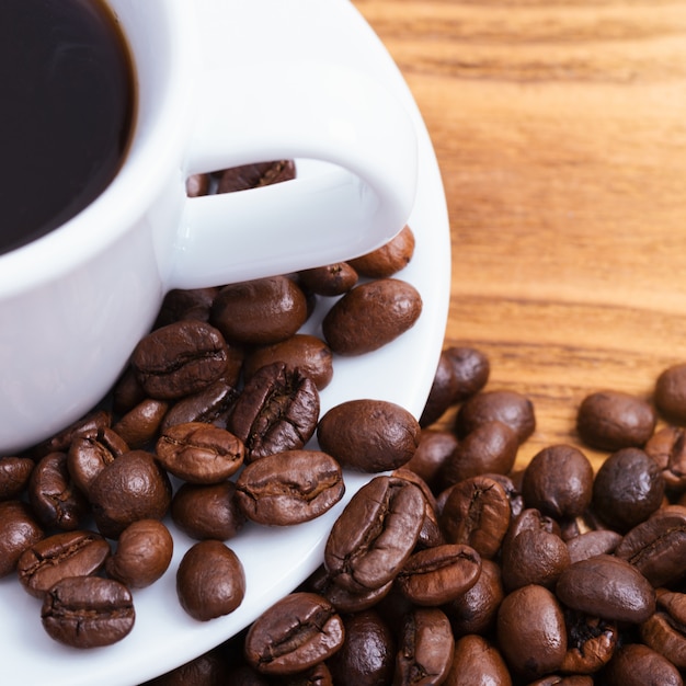 taza de café y granos de café dispersos.