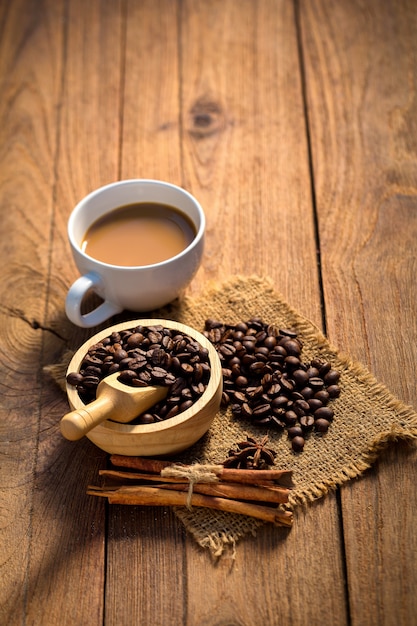 Taza de café y granos de café en el fondo de madera.