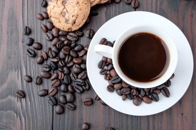 Foto taza de café y granos de café en el fondo de madera.