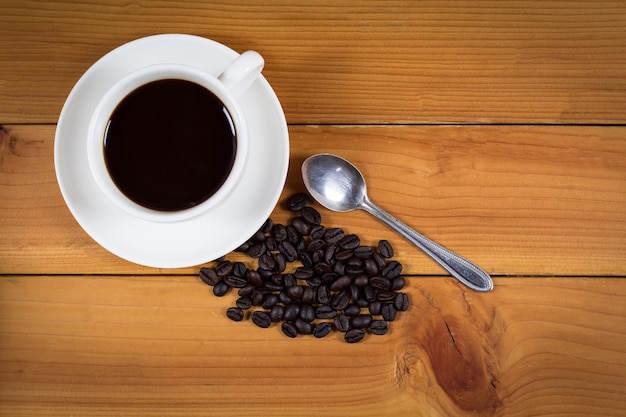 Taza de café y granos de café en madera