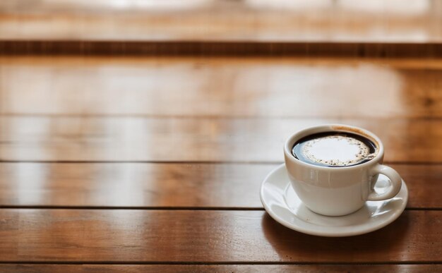 Foto una taza de café y granos de café en la mesa de madera