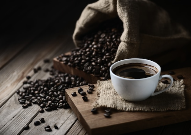 Taza de café y granos de café en una mesa de madera