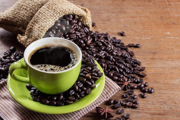 Taza de café y granos de café en la mesa de madera