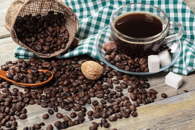 Taza de café y granos de café en la mesa