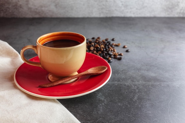 Taza de café y granos de café en la mesa