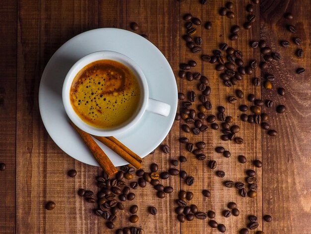 Taza de café y granos de café en la mesa