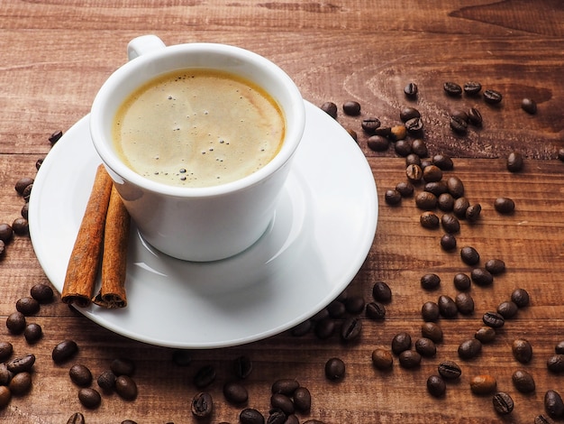 Taza de café y granos de café en la mesa