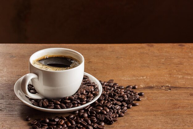 Taza de café y granos de café en la mesa