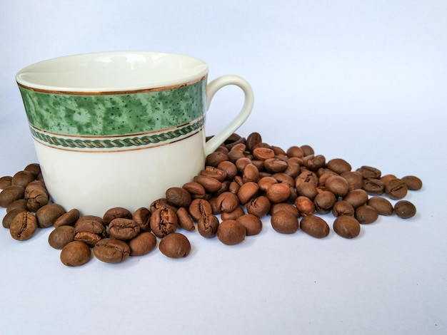 Taza de café y granos de café sobre fondo blanco