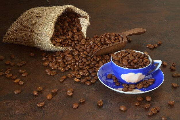 Taza de café y granos de café sobre fondo de madera vieja