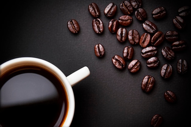 Taza de café y granos de café sobre fondo negro Vista superior