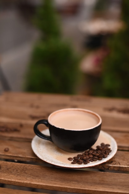 Taza de café con granos de café sobre una mesa de madera