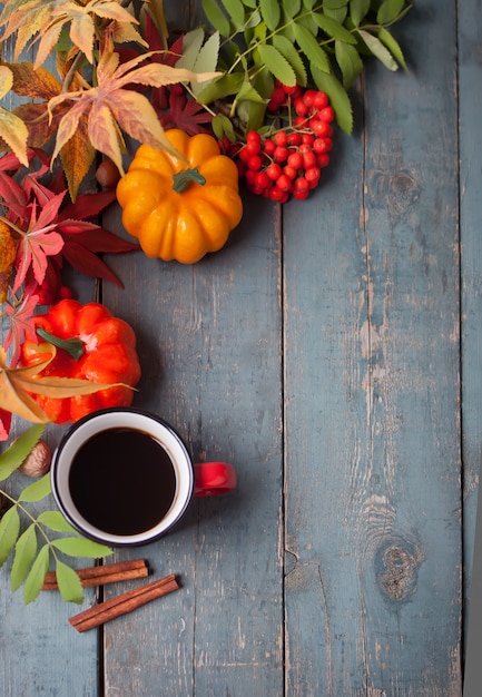 Taza de café con hojas de otoño y calabazas pequeñas