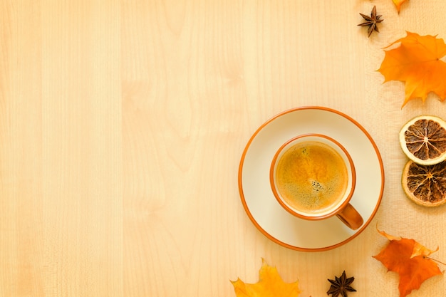 Taza de café y hojas de otoño en madera