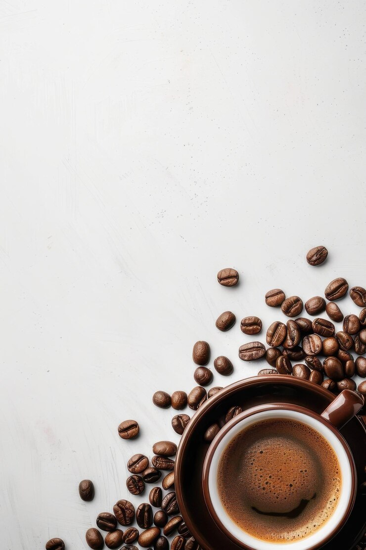 Una taza de café humeante rodeada de frijoles tostados sobre un fondo oscuro que evoca una sensación de calor