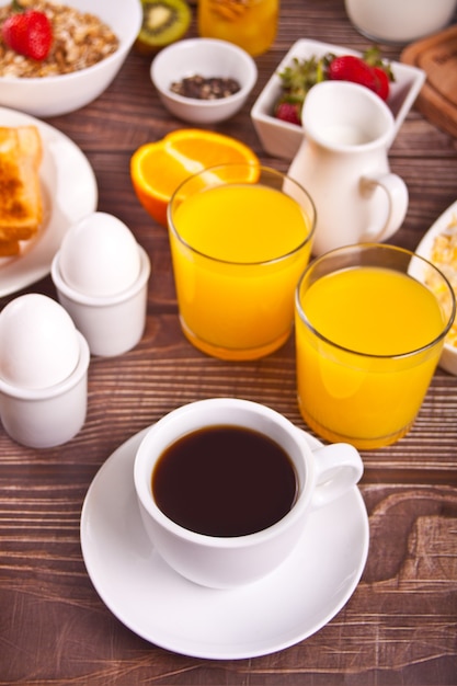 Taza de café, jugo, huevos, frutas, tostadas. Concepto de desayuno.