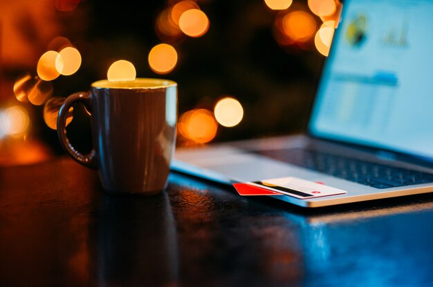 Taza de café y laptop en decoración navideña