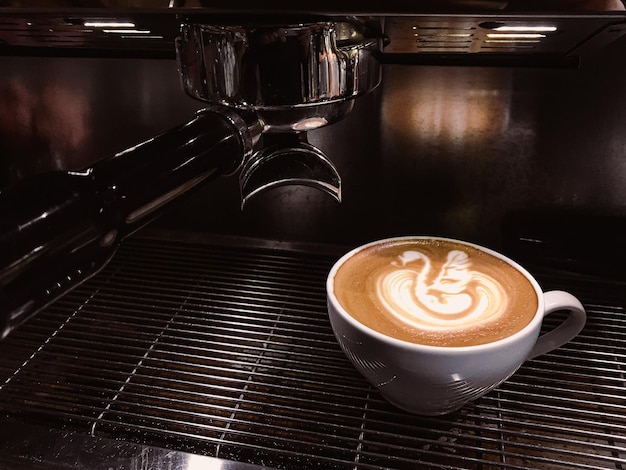 taza de café latte art y cafetera