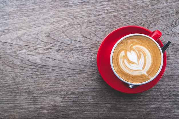 Taza de café Latte Art en la mesa de madera, plana