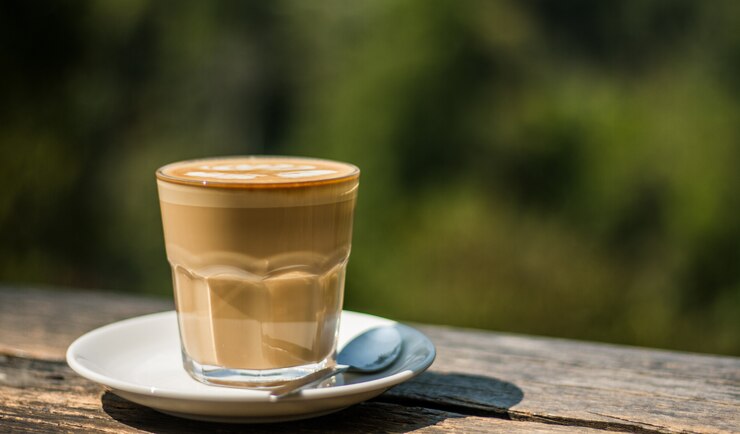 Taza de café con leche en la barra de madera en la cafetería