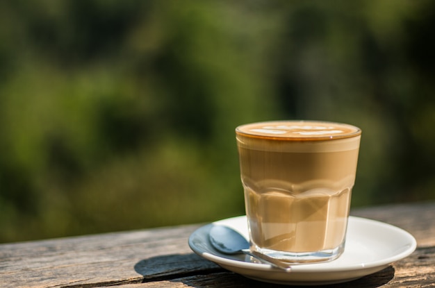 Taza de café con leche en la barra de madera en la cafetería
