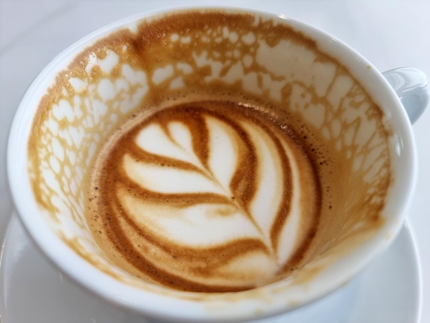 Una taza de café con leche caliente después de beber sobre fondo de madera