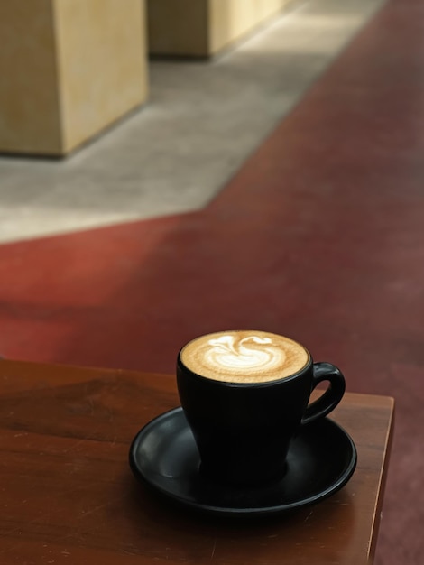 Una taza de café con leche caliente en la mesa para el desayuno