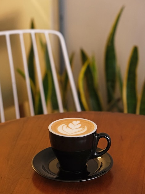 Una taza de café con leche caliente en la mesa para el desayuno