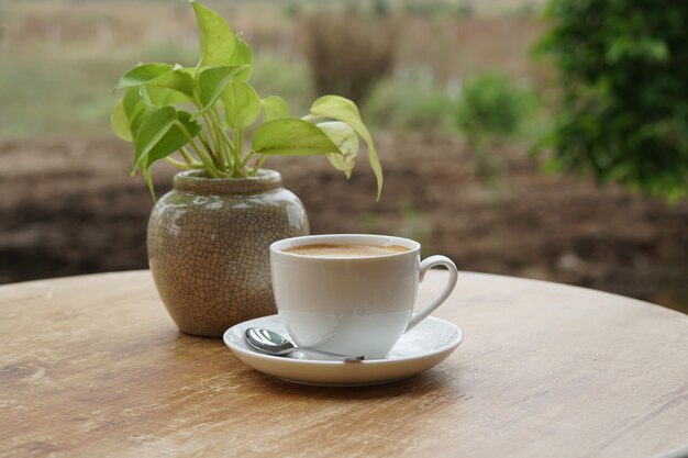 Una taza de café con leche caliente en la mesa de madera